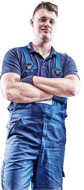 A person in blue work clothes with their arms crossed.