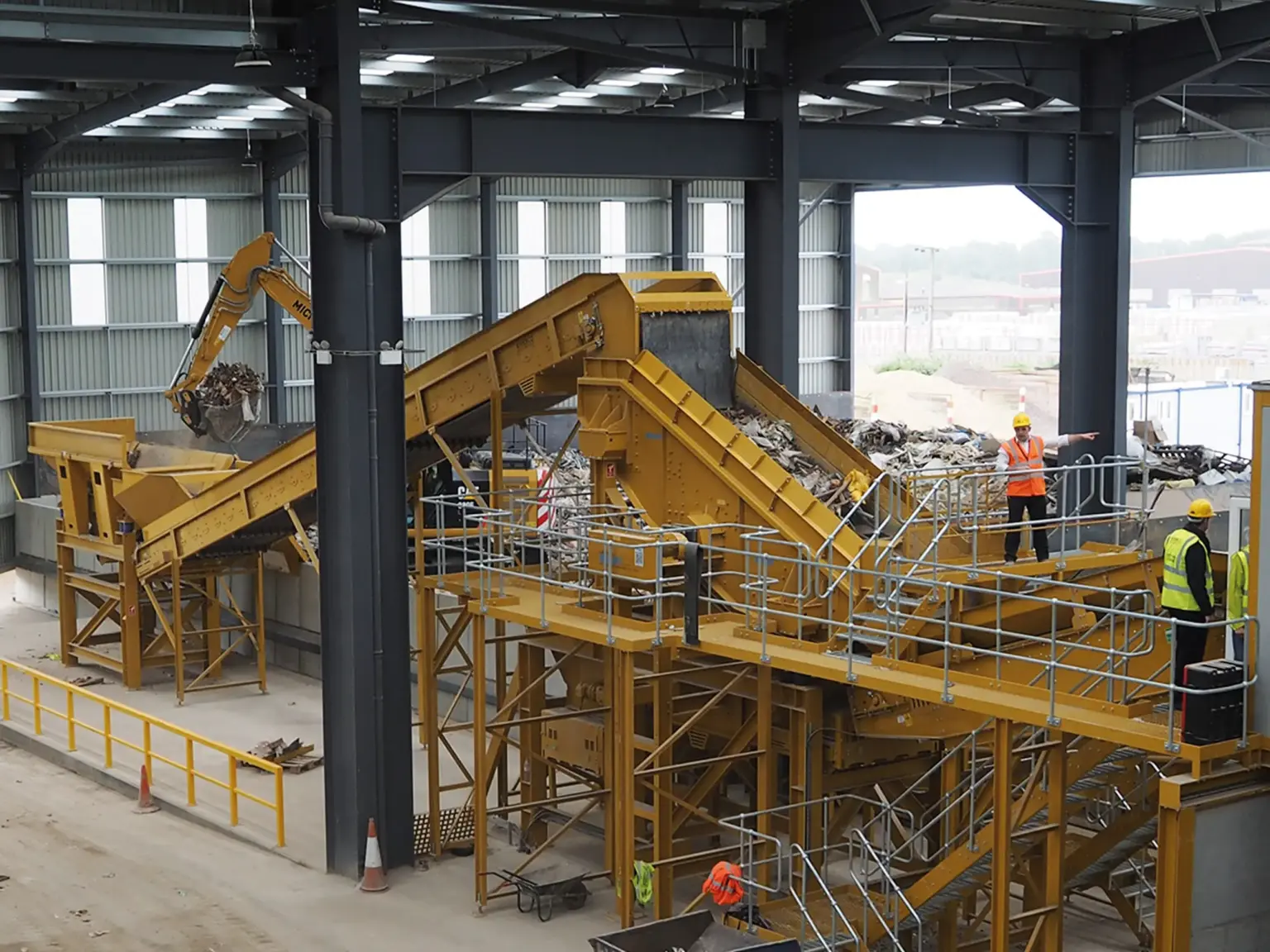 Industrial facility with conveyor belts and a Recycling Waste Screen in a warehouse.