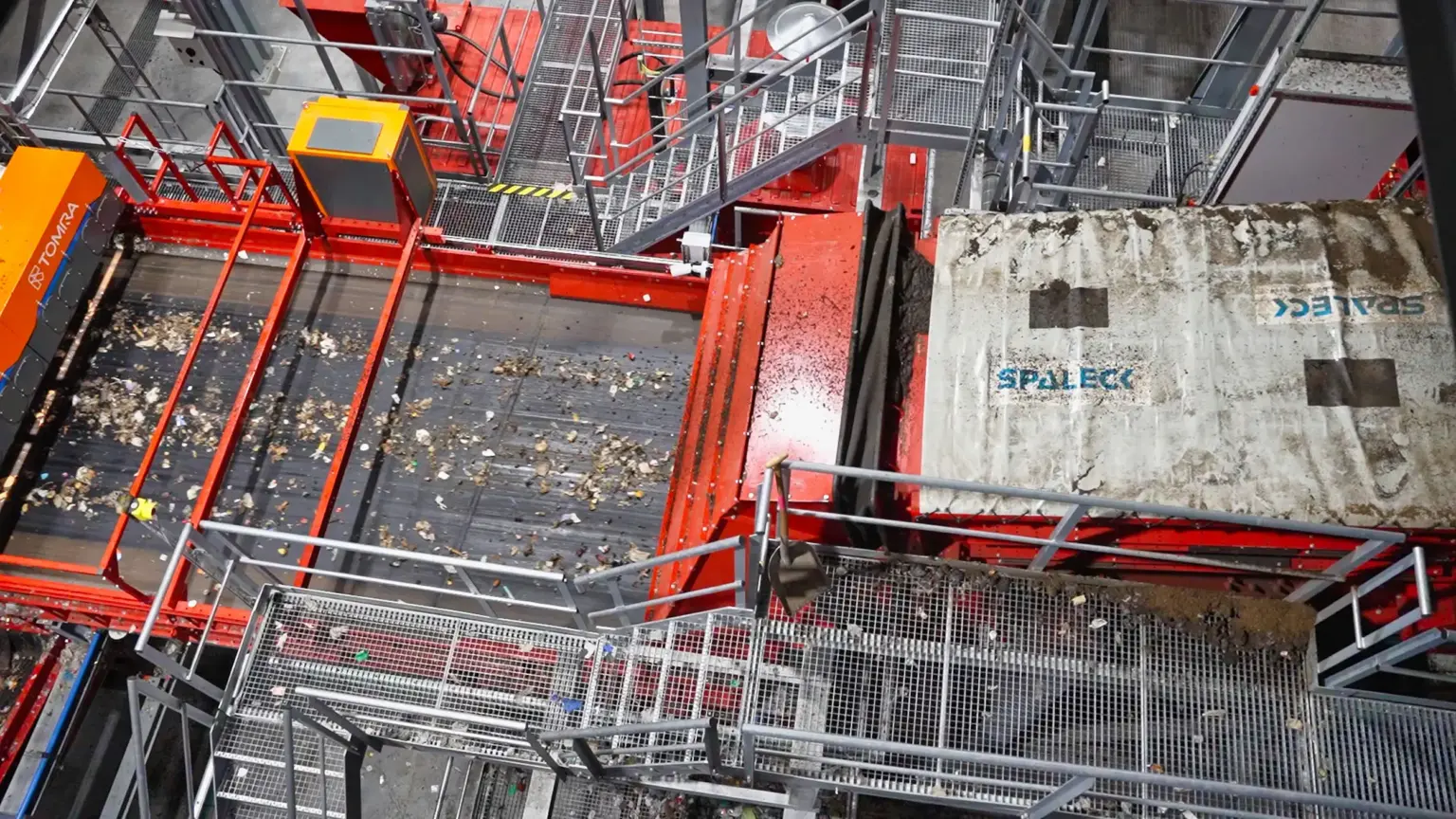 Spannwellensiebmaschine (Flip-Flow Sieb) vor einem Sortiergerät in einer Hausmüll-Recyclinganlage. Die SPALECK Spannwellensiebmaschine liefert exakt gesiebtes Material. Die Absiebung des Feinanteils hilft hier, dass die nachfolgende Sensorsortierung (Tomra Machine) optimal funktionieren kann.