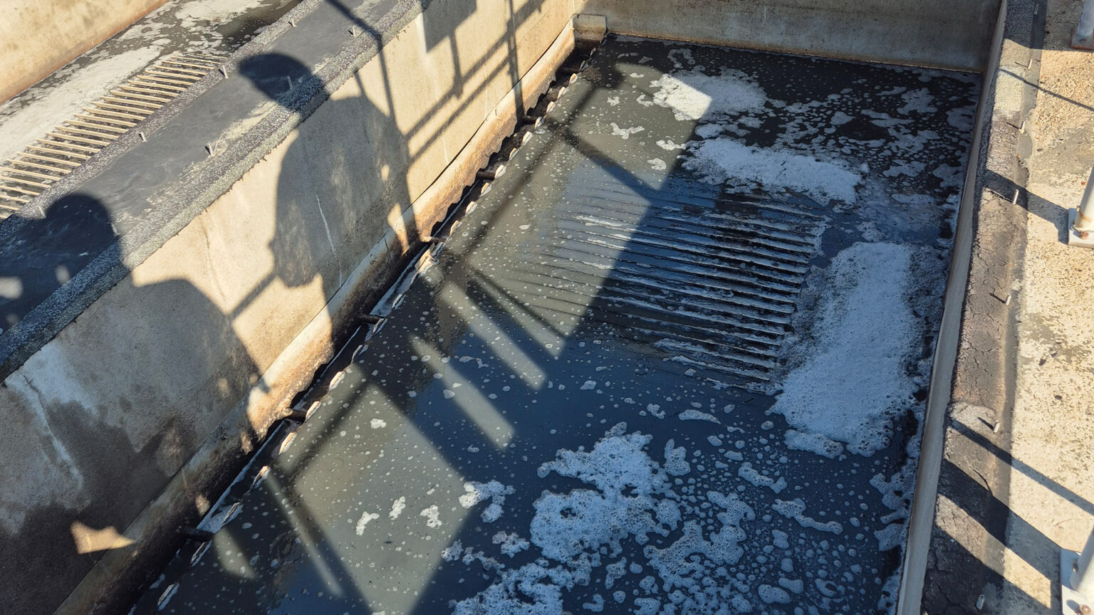 A tank containing wastewater in which flocs and foam form along with the contaminants.
