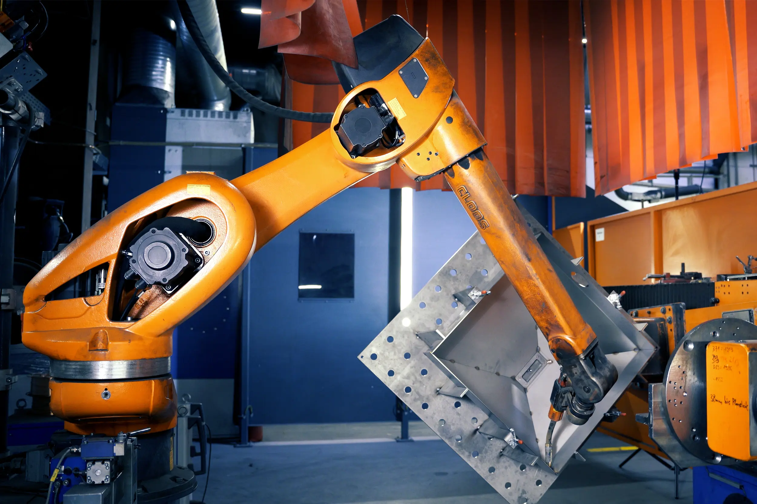 Ein Schweißroboter setzt zum automatisierten Schweißen eines Bauteils für die Schienenfahrzeugindustrie an. Aufgenommen wurde das Bild beim Lohnfertiger und Metallverarbeiter SPALECK.